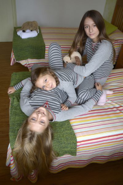 3 hermanas juegan en su habitación vestidas con sus pijamas a juego