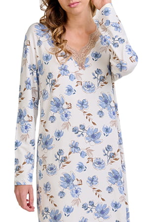 Mujer luciendo un camisón blanco de manga larga con estampado floral azul y encaje en el escote