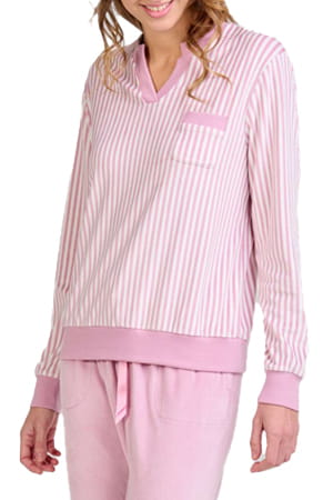 Mujer luciendo pijama de invierno con top a rayas rosa claro y blanco, bolsillo en el pecho y pantalón rosa claro a juego.